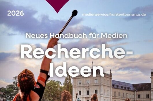 Menschen mit Trommeln auf einer Bühne vor großem Publikum vor einem Schloss, Text zu Recherche-Ideen 2026