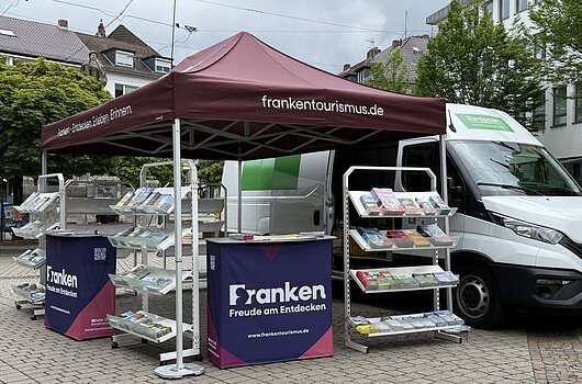 FrankenTour 2026, Darmstadt Mobiler Informationsstand mit Prospektständern und Zelt „frankentourismus.de“ vor einem weißen Transporter.