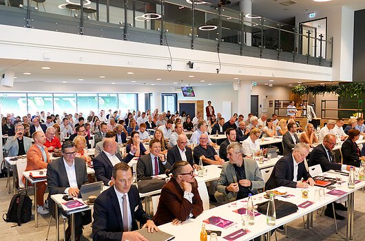 Mitgliederversammlung 2026, Fürth Großer Konferenzraum mit vielen sitzenden Personen bei einer Versammlung mit Tischen und Unterlagen.